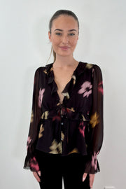 Woman wearing a chiffon blouse with floral graphic allover
