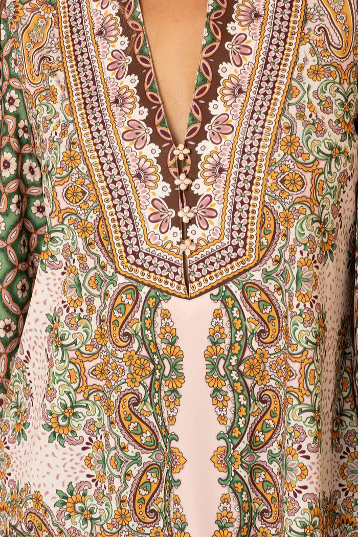 Close-up of a patterned v-neck top with intricate and colourful designs.