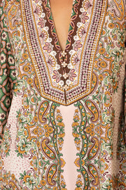Close-up of a patterned v-neck top with intricate and colourful designs.