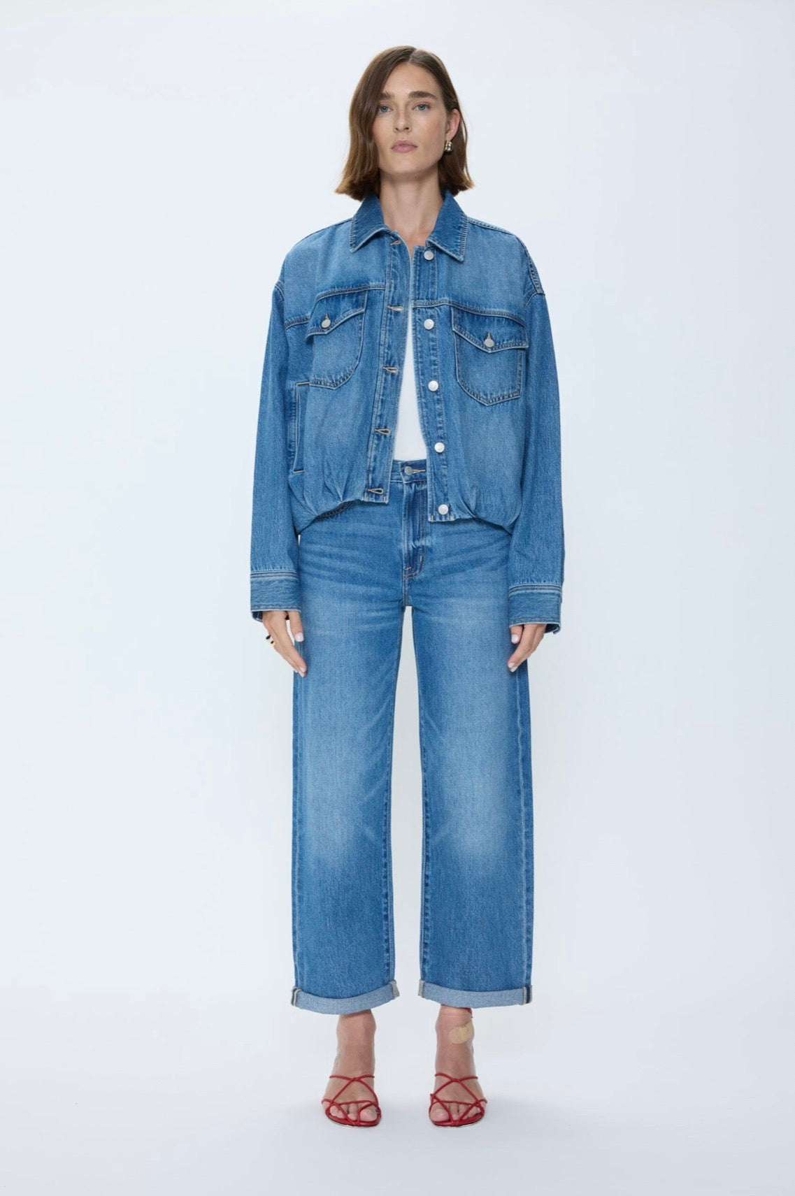 Woman wearing a mid washed blue wide leg rolled hem pair of jeans