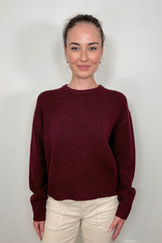 Front view of woman wearing a wine coloured crew-neck sweater 