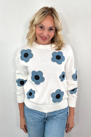 Woman wearing a while knit follower with denim floral design