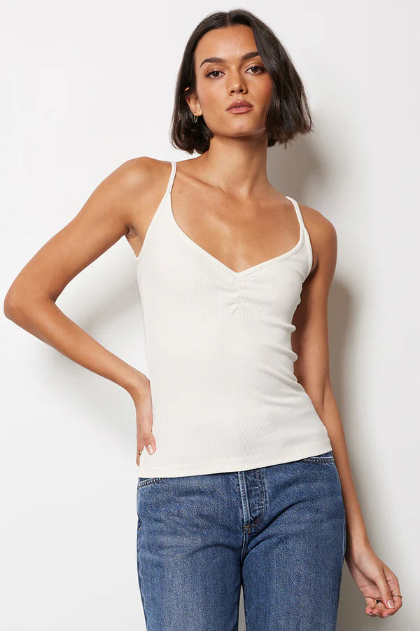 Woman wearing a white shirred tank top 
