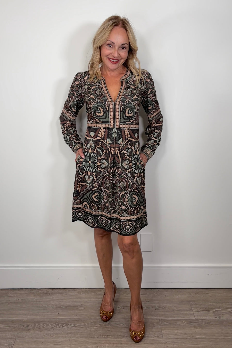 woman wearing short green long sleeve patterned dress