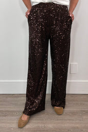 Person wearing brown sequin pants against a plain background