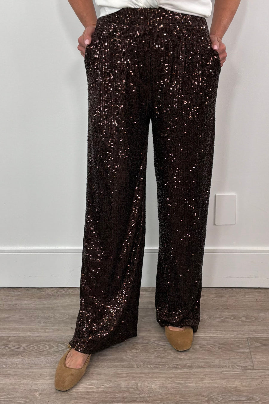 Person wearing brown sequin pants against a plain background