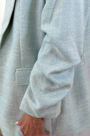 Close up of an light turqoise rouched sleeve from a open blazer