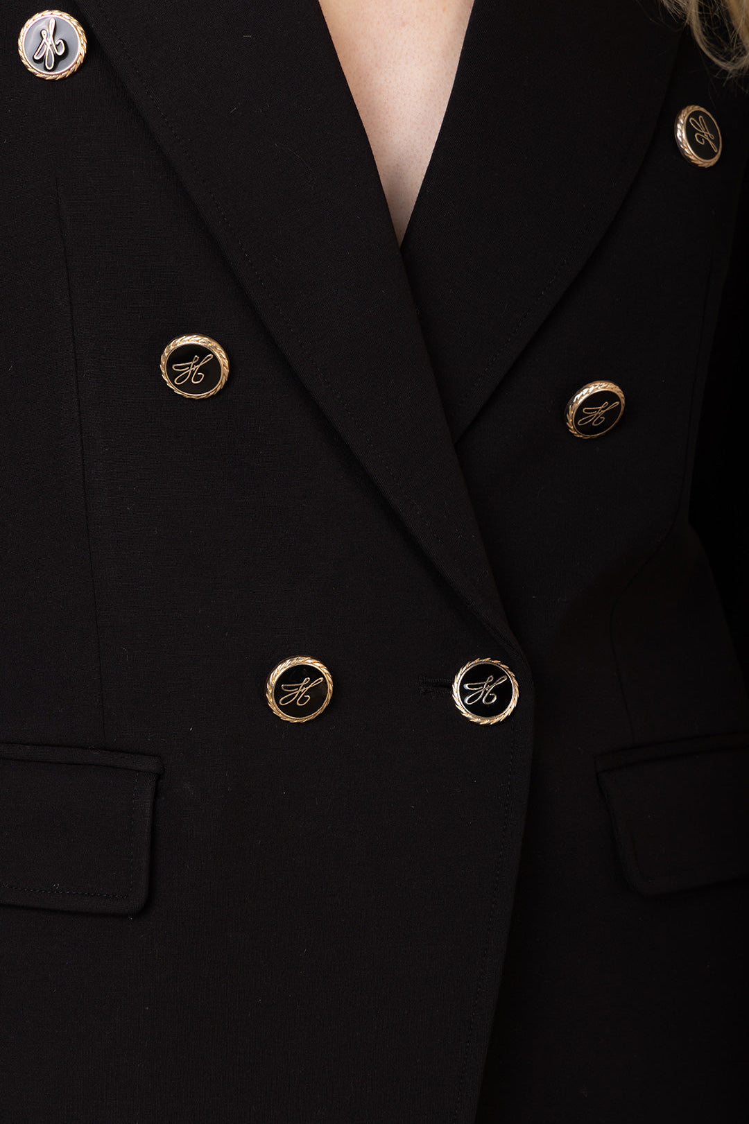 Black double-breasted black blazer with gold buttons on a dark background