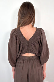 Back of women wearing a linen brown half sleeve blouse