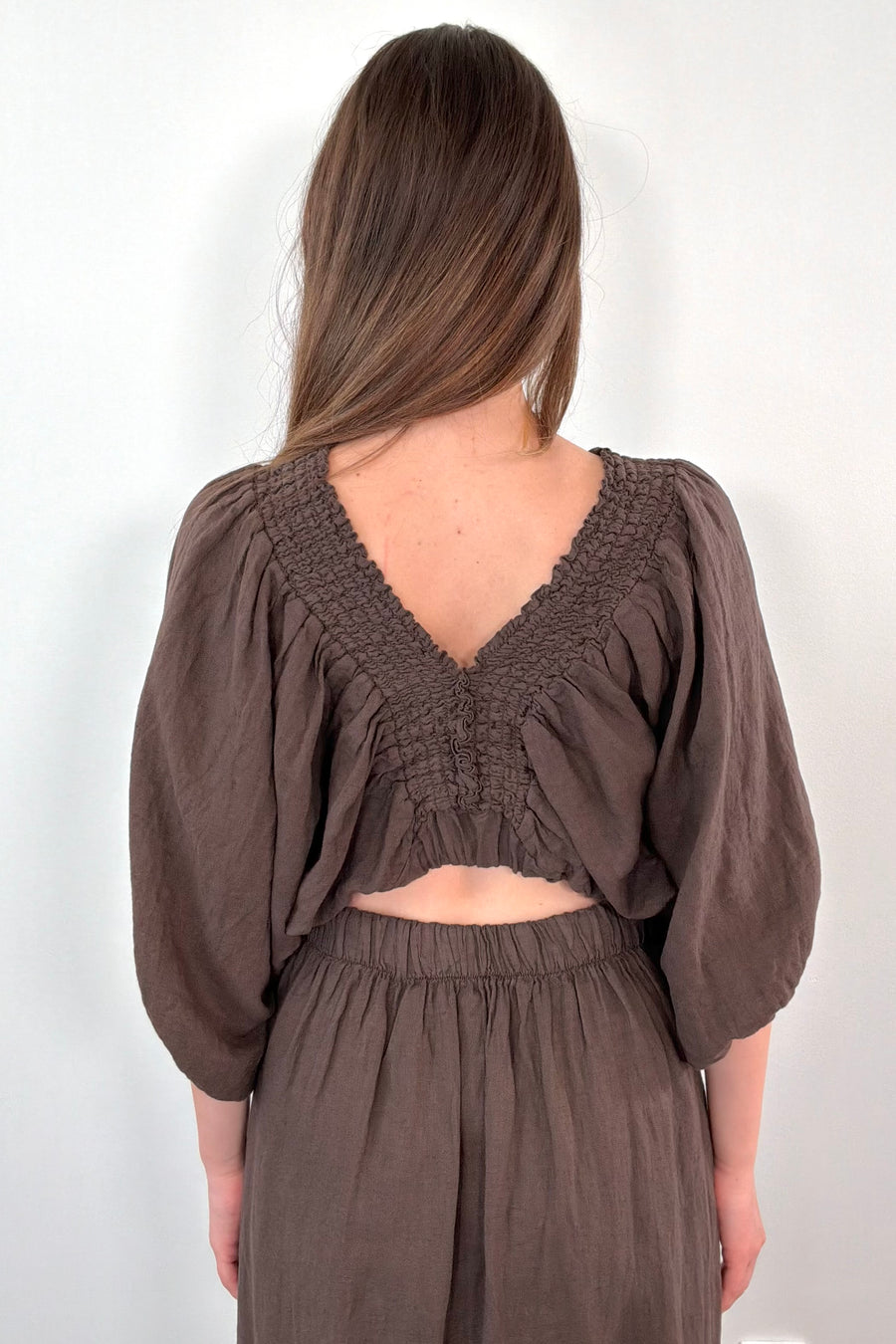 Back of women wearing a linen brown half sleeve blouse