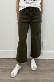Woman wearing a dark green cropped flare denim with pockets on the front of the leg
