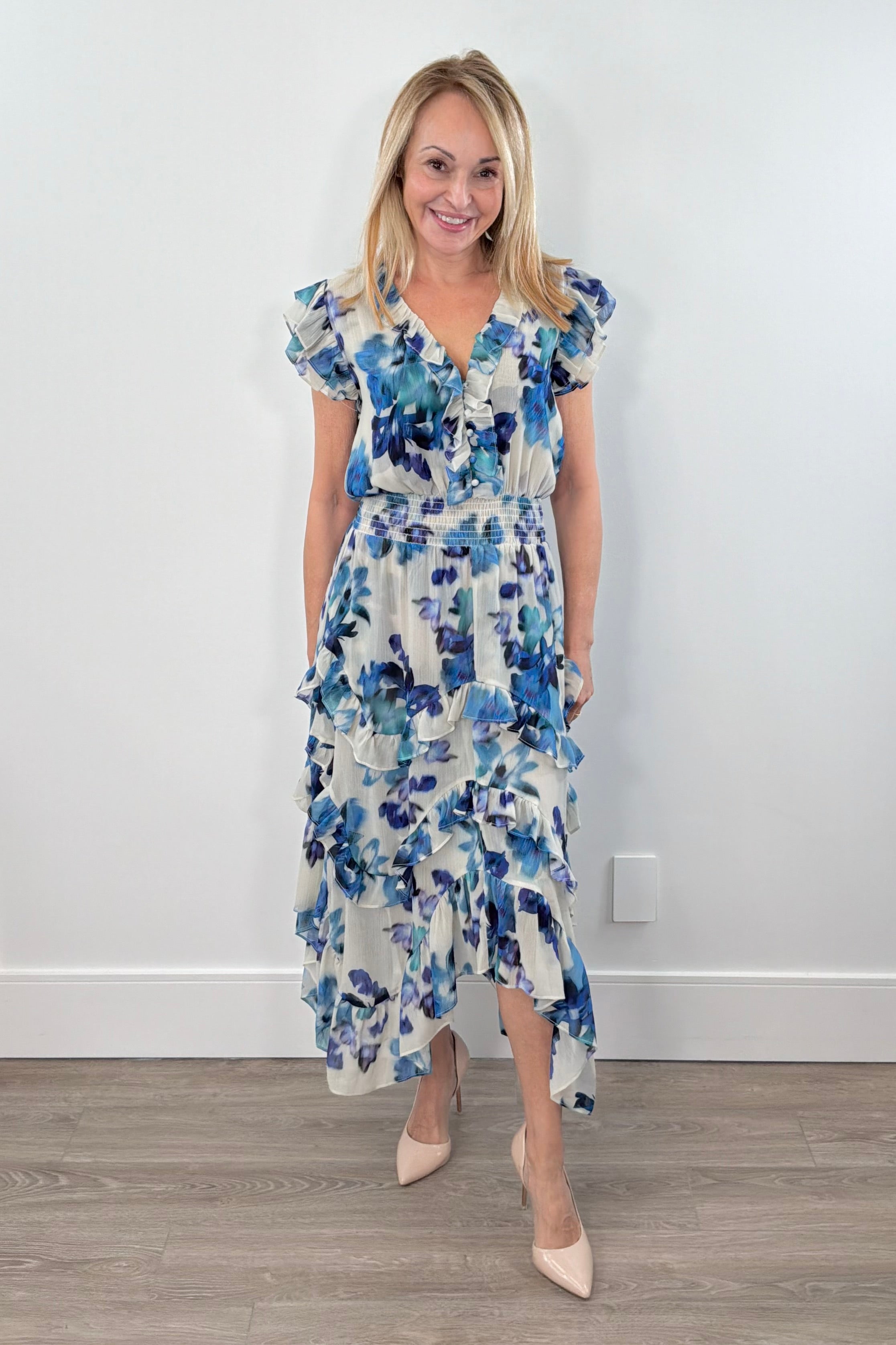 Woman wearing a blue floral print ruffle dress