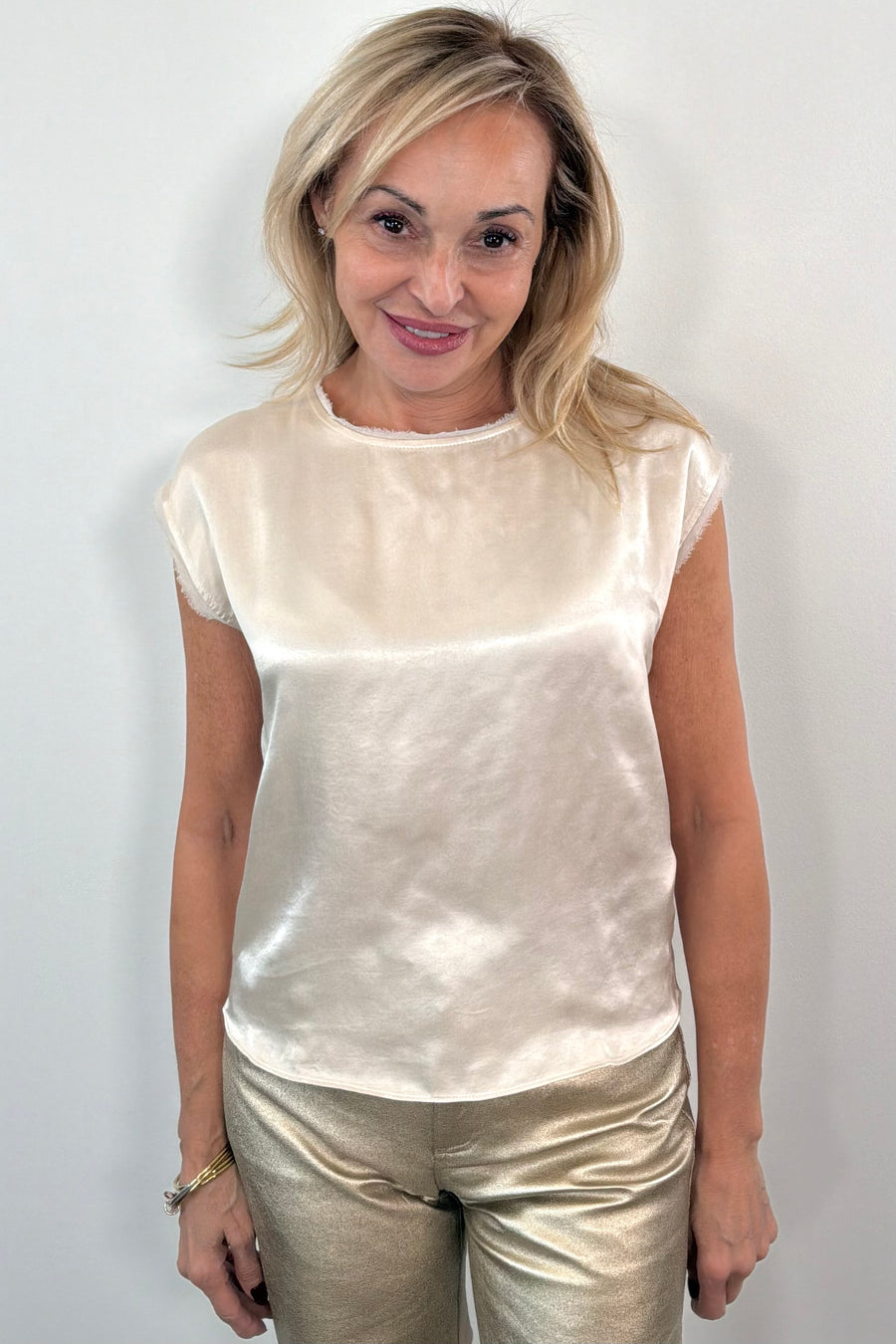woman wearing a cream satin cap sleeved top