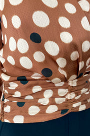 Close-up of a brown fabric with white and black polka dots