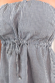 Close-up of the waist detail on a light, blue and white striped strapless top