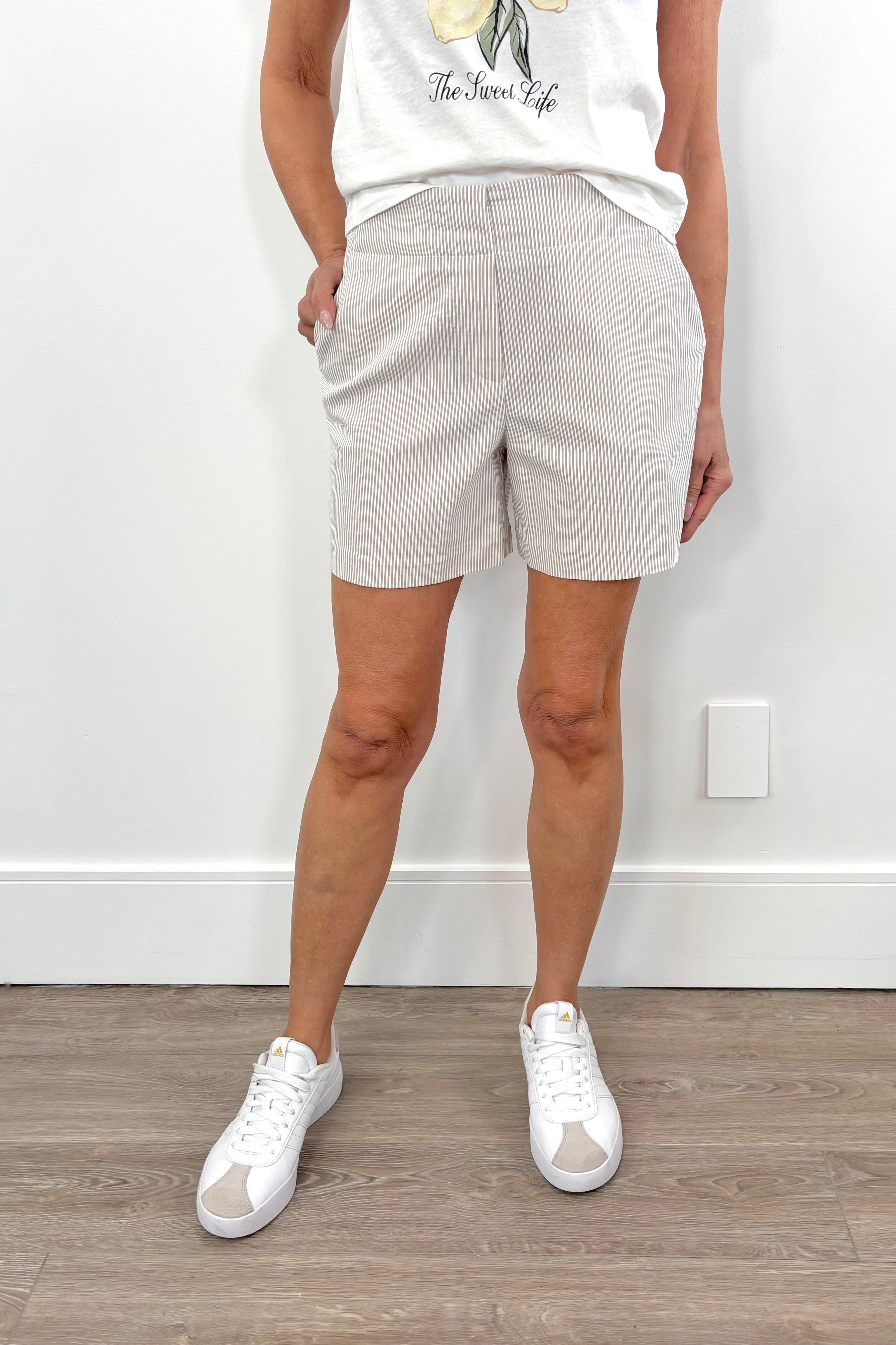 Woman wearing beige shorts with subtle stripes