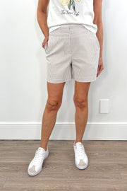 Woman wearing beige shorts with subtle stripes