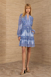 Woman wearing a blue patterned long sleeve short dress