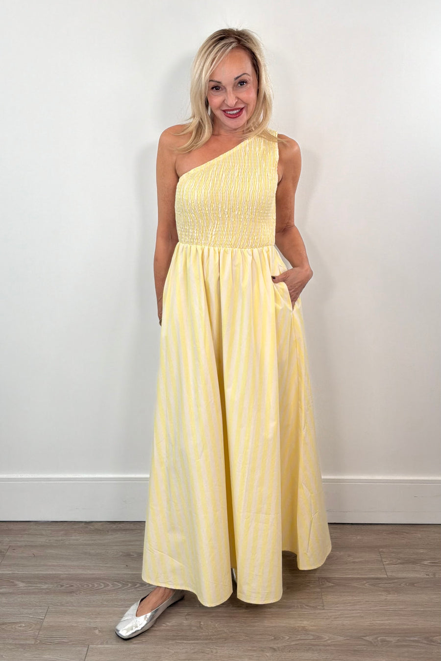 woman wearing a one-shoulder elastic torso yellow and white stripped dress