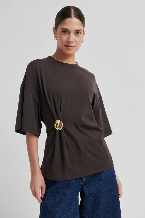 Woman wearing a brown short-sleeve crewneck top with a side ring detail, front
