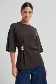Woman wearing a brown short-sleeve crewneck top with a side ring detail, front