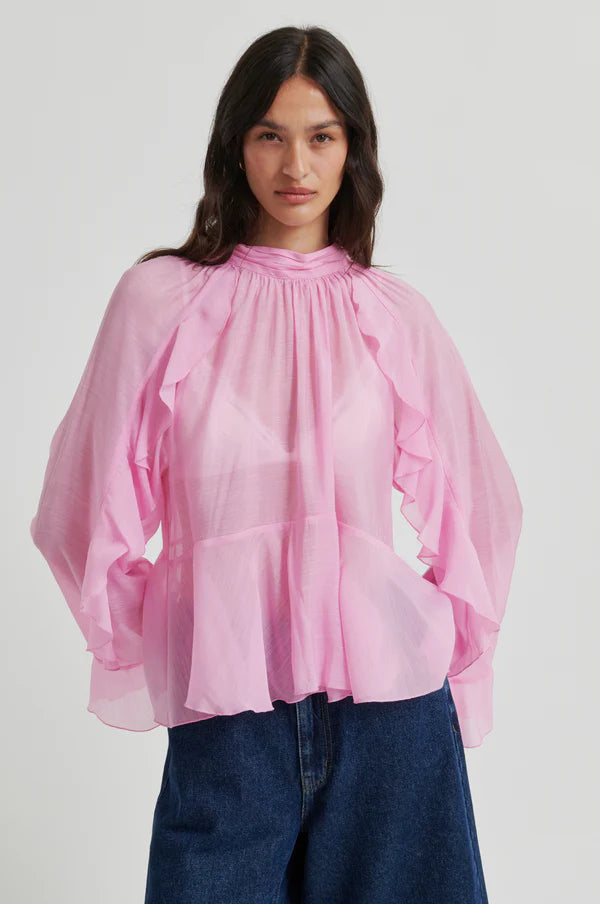 Pink long-sleeve blouse with ruffle details, high neckline, and flowy silhouette, front