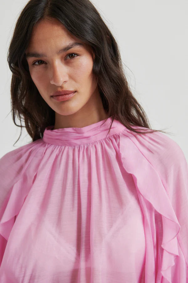 Pink long-sleeve blouse with ruffle details, high neckline, and flowy silhouette, detail