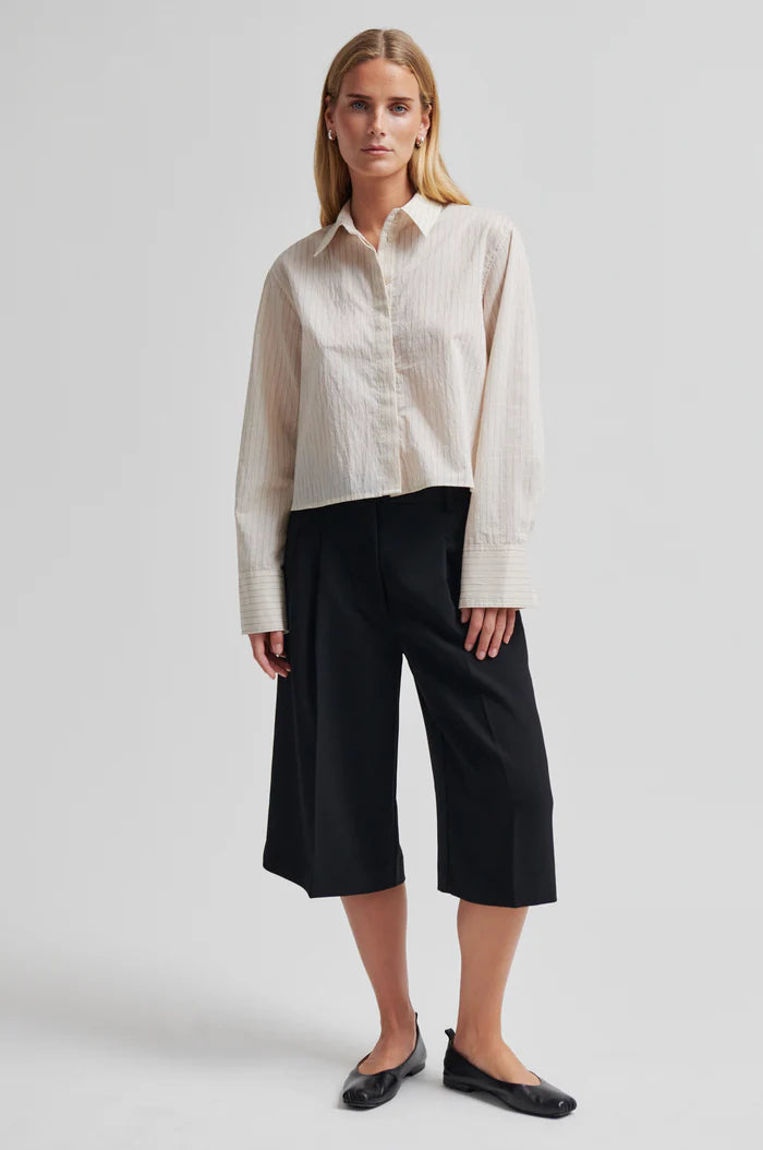 Woman wearing oversized black Bermuda shorts with pockets