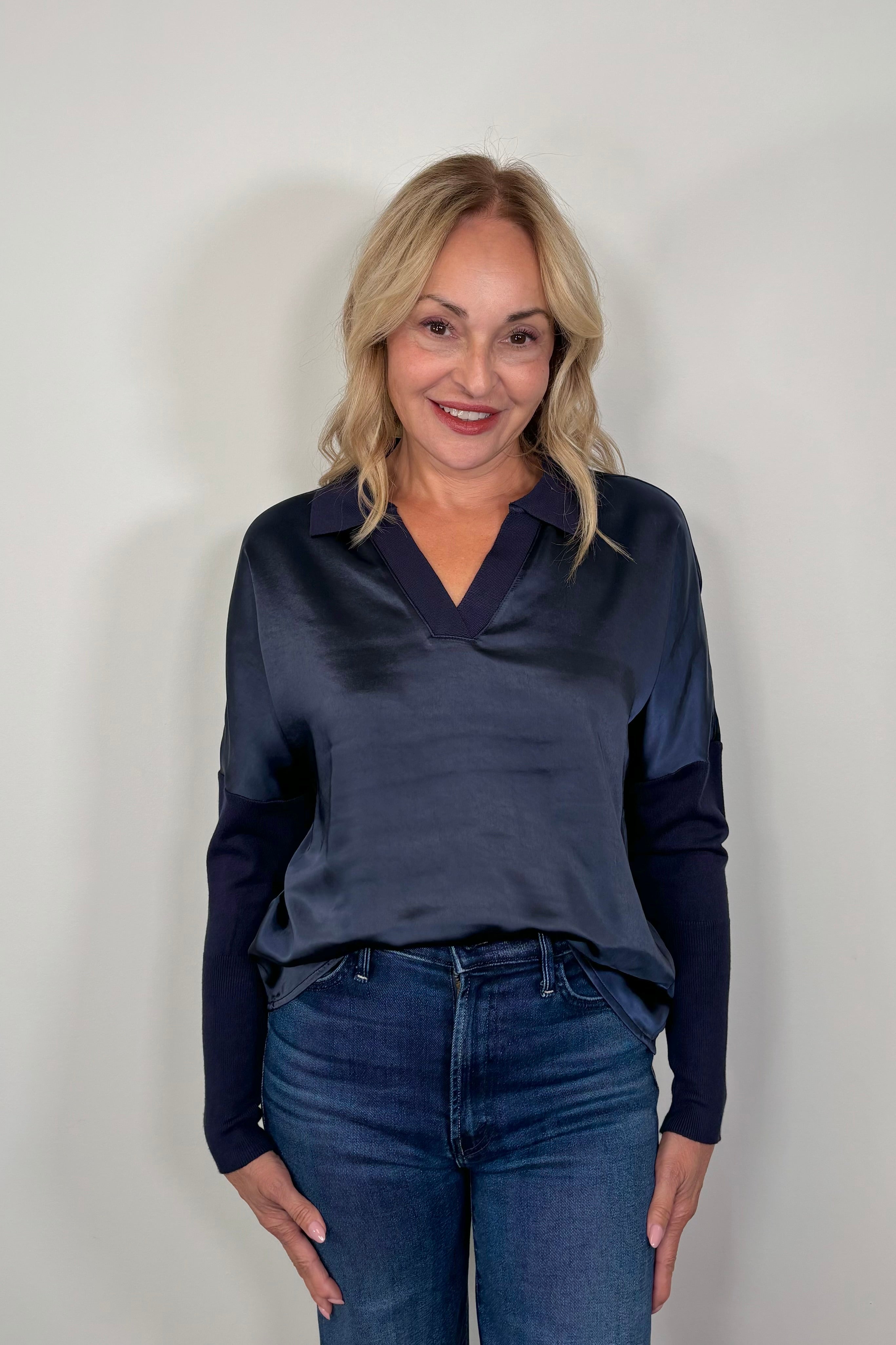 woman wearing a navy jersey and satin long sleeve collared too