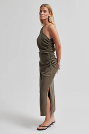 Woman wearing a one-shoulder olive green dress with ruched detail. 