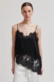 Woman wearing a asymmetrical black lace-trimmed top 