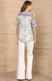 Woman wearing a patterned button up top in blue