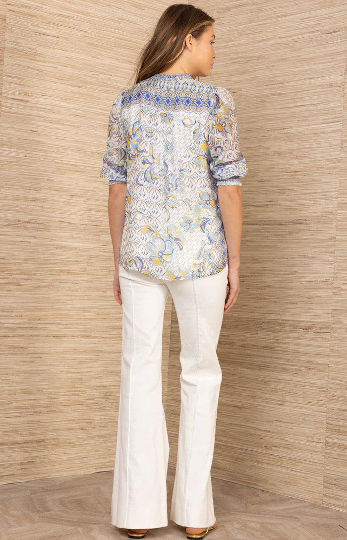 Woman wearing a patterned button up top in blue