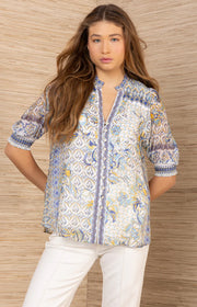Woman wearing a patterned button up top in blue
