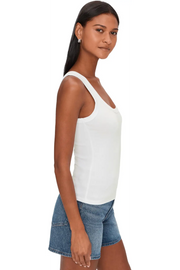 Woman wearing a white ribbed tank top with scoop neckline