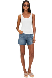 Woman wearing a white ribbed tank top with scoop neckline