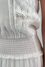 close-up of a maxi strapless white dress with lace details in the skirt
