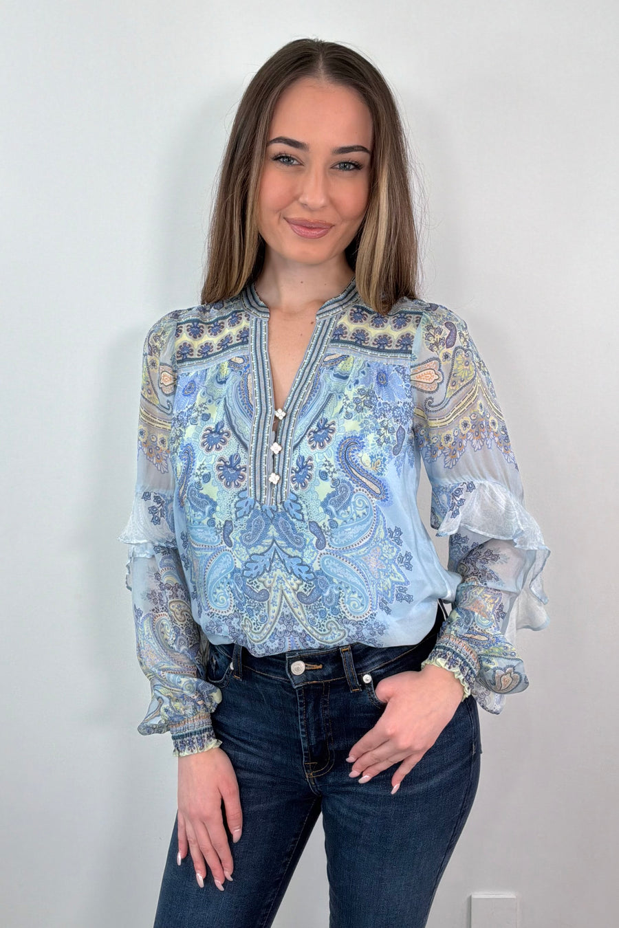 woman wearing a blue paisley patterned silk ruffle blouse