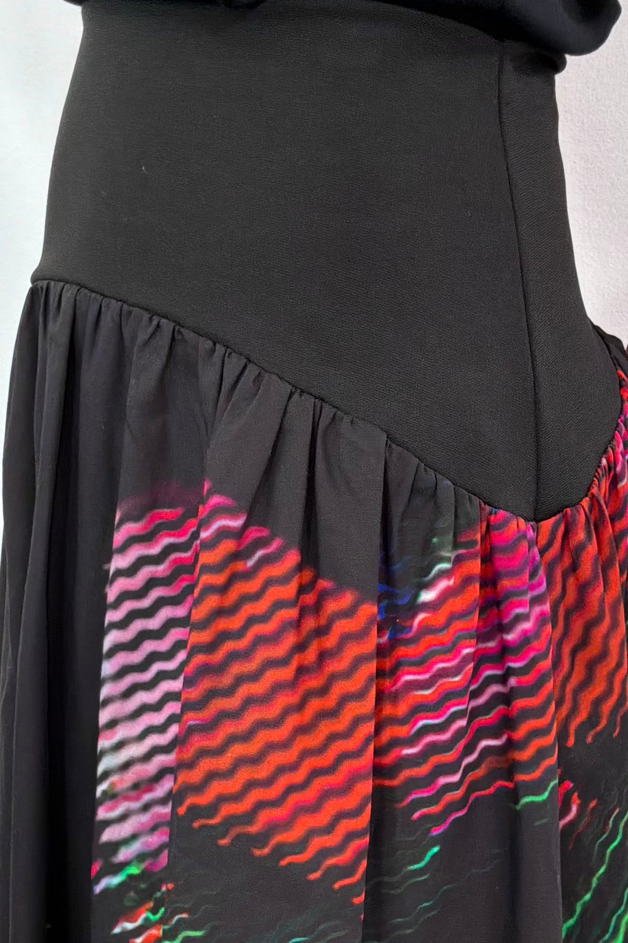 close-up of the elastic waist of a black poplin skirt with a floral design on the side
