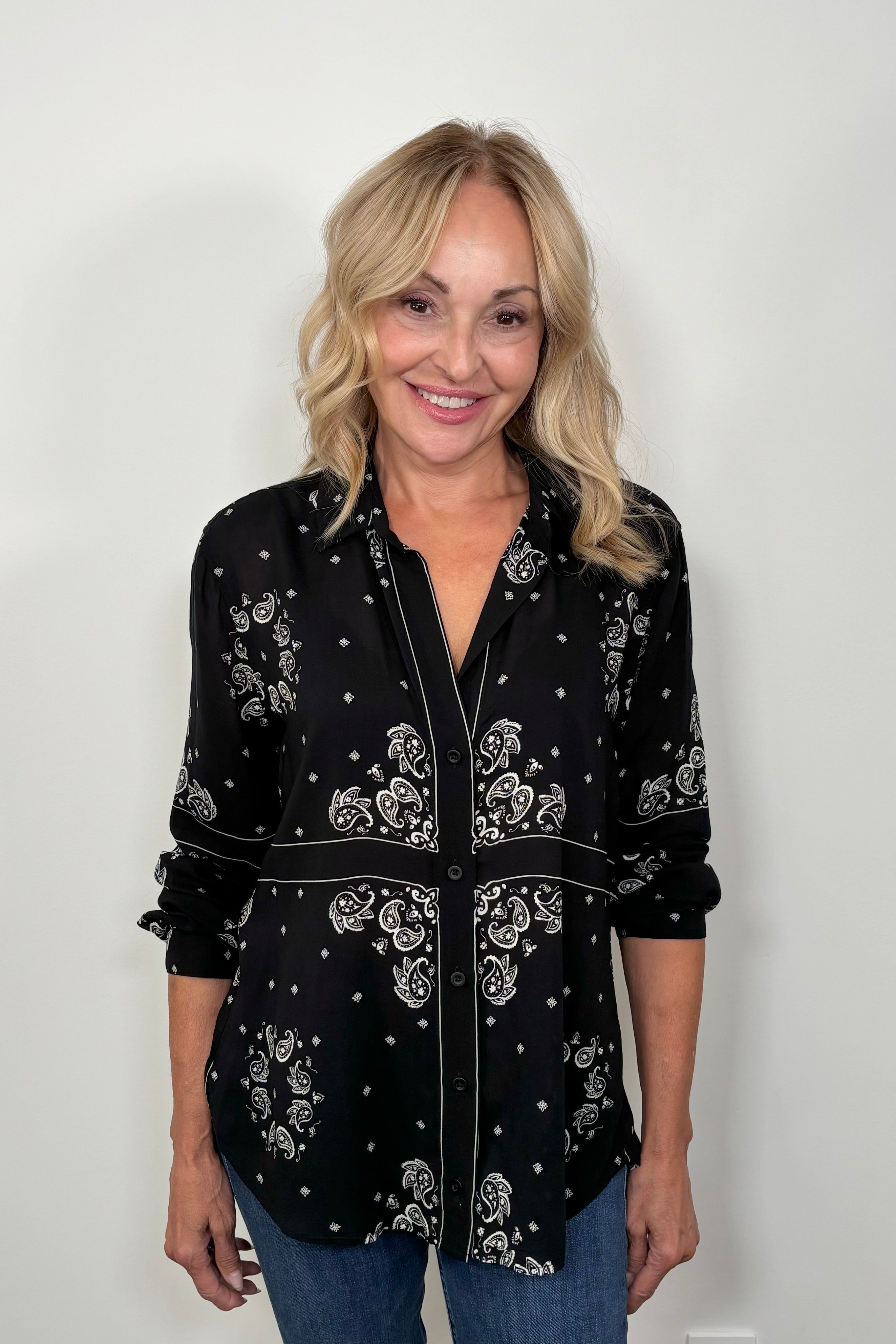 Front view of woman wearing a bandana-patterned button down blouse