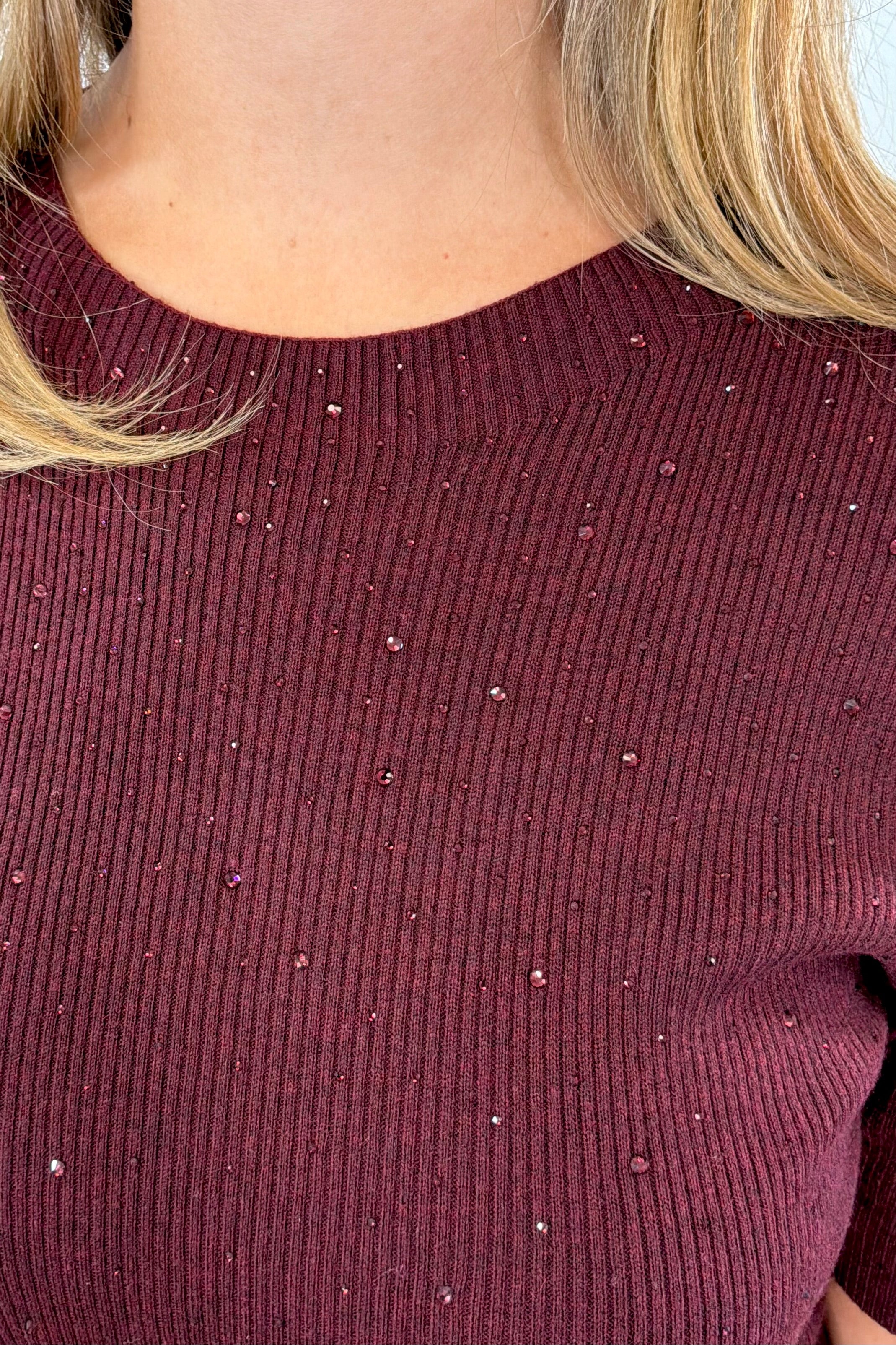 Woman wearing a maroon knit top 