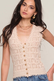 Close up of Woman wearing a light beige knit vest with button up detail
