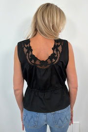 Back view of Woman wearing a sleeveless top with neckline detail in black