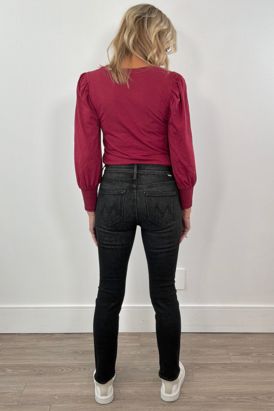 woman wearing washed black fitted jeans and a red top