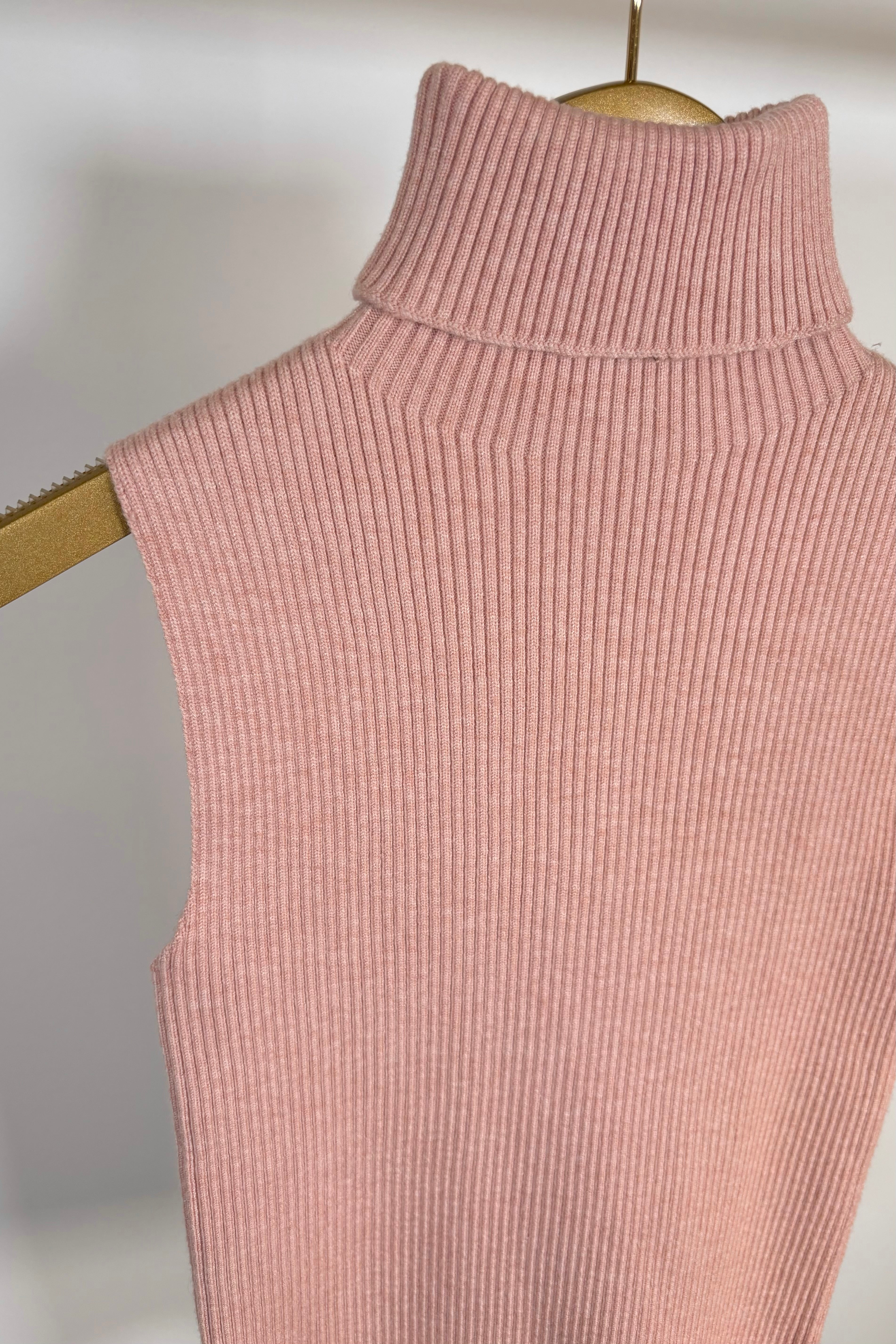 Close up of pink knitted turtleneck tank top