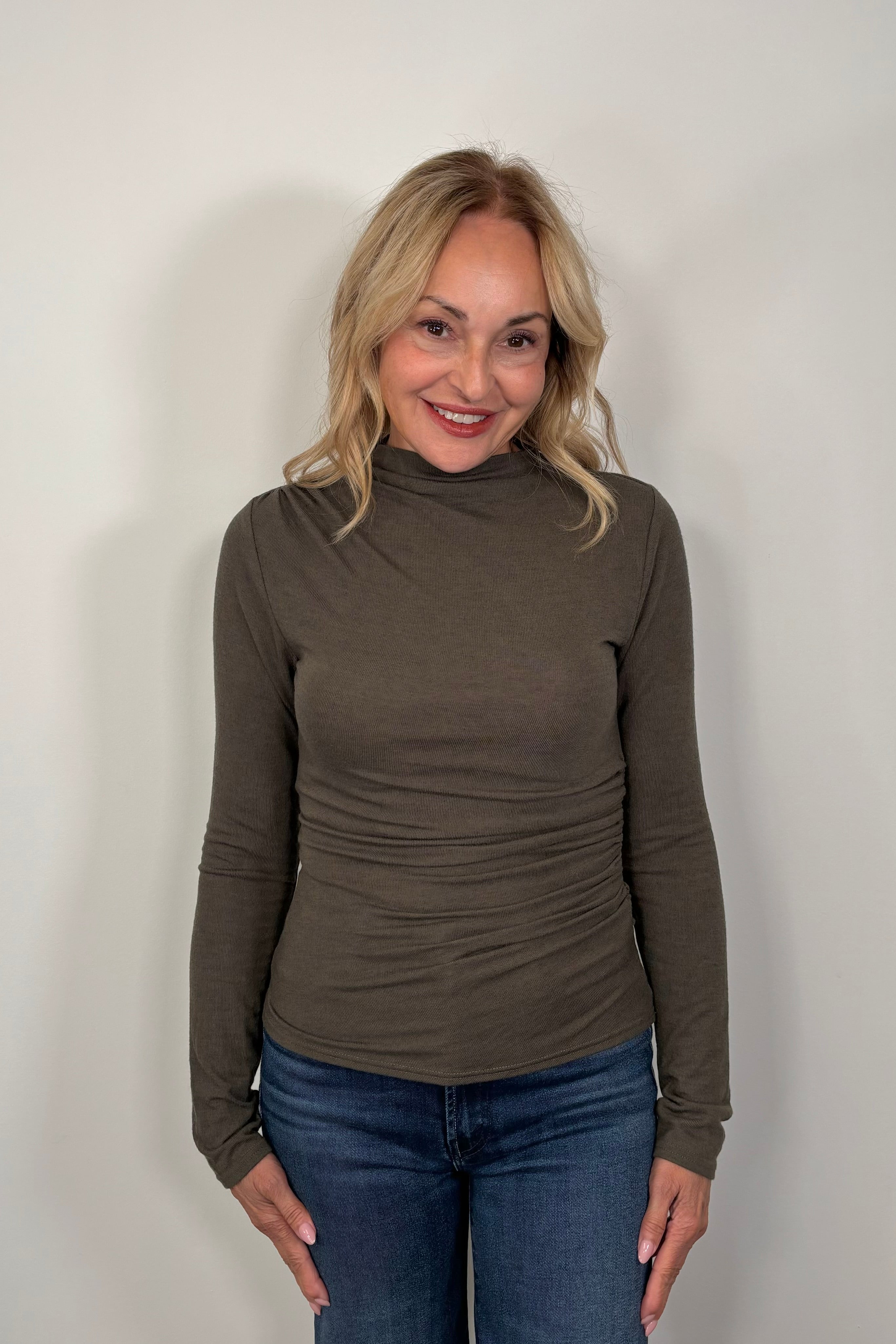 woman wearing a mock neck rouched long sleeve top