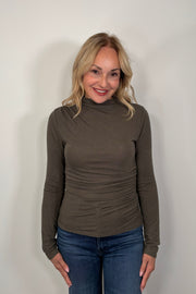 woman wearing a mock neck rouched long sleeve top