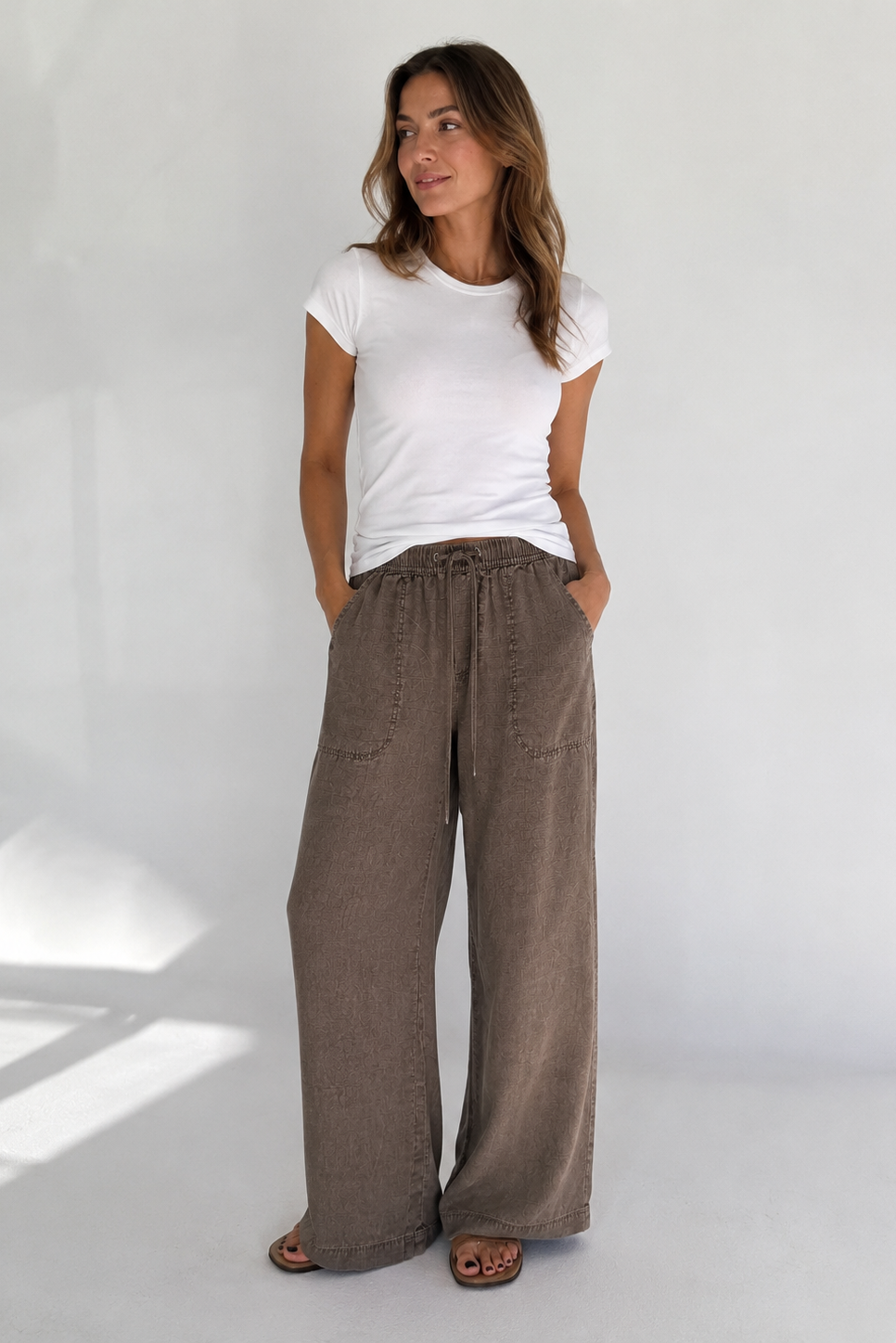 woman wearing brown draw string pants with a wide leg 