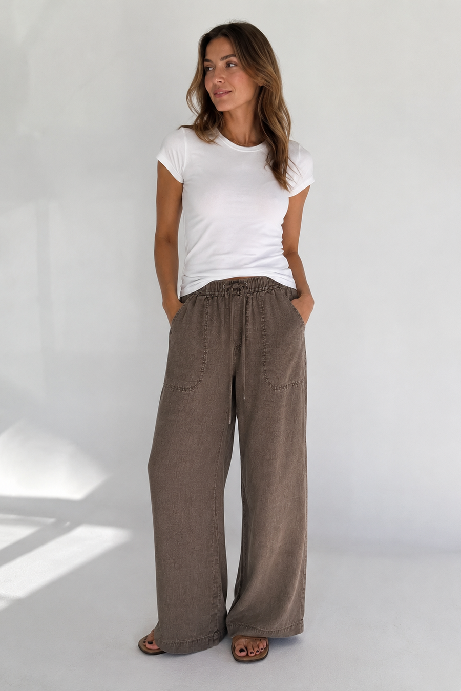 woman wearing brown draw string pants with a wide leg 