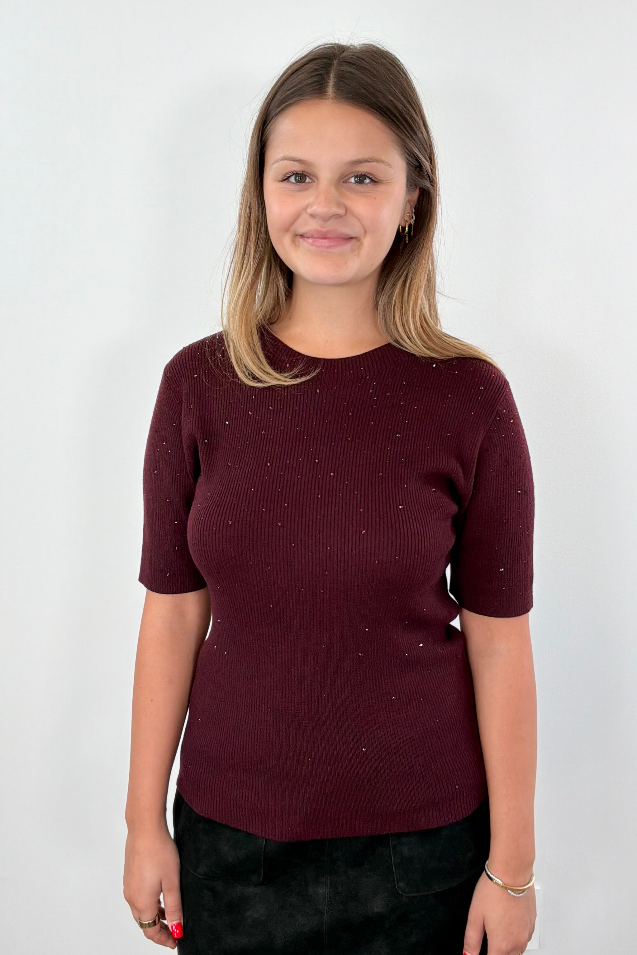 Woman wearing a maroon knit top 